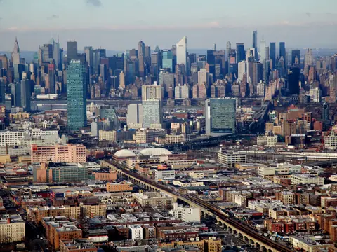 The Manhattan skyline seen from the air across the rooftops of Queens