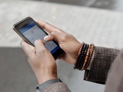 Two hands holding a smartphone that shows a map with a location pin