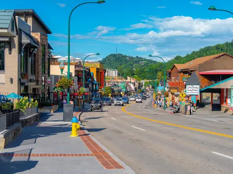 A small town main street on a sunny day with shops on both sides and painted crossings