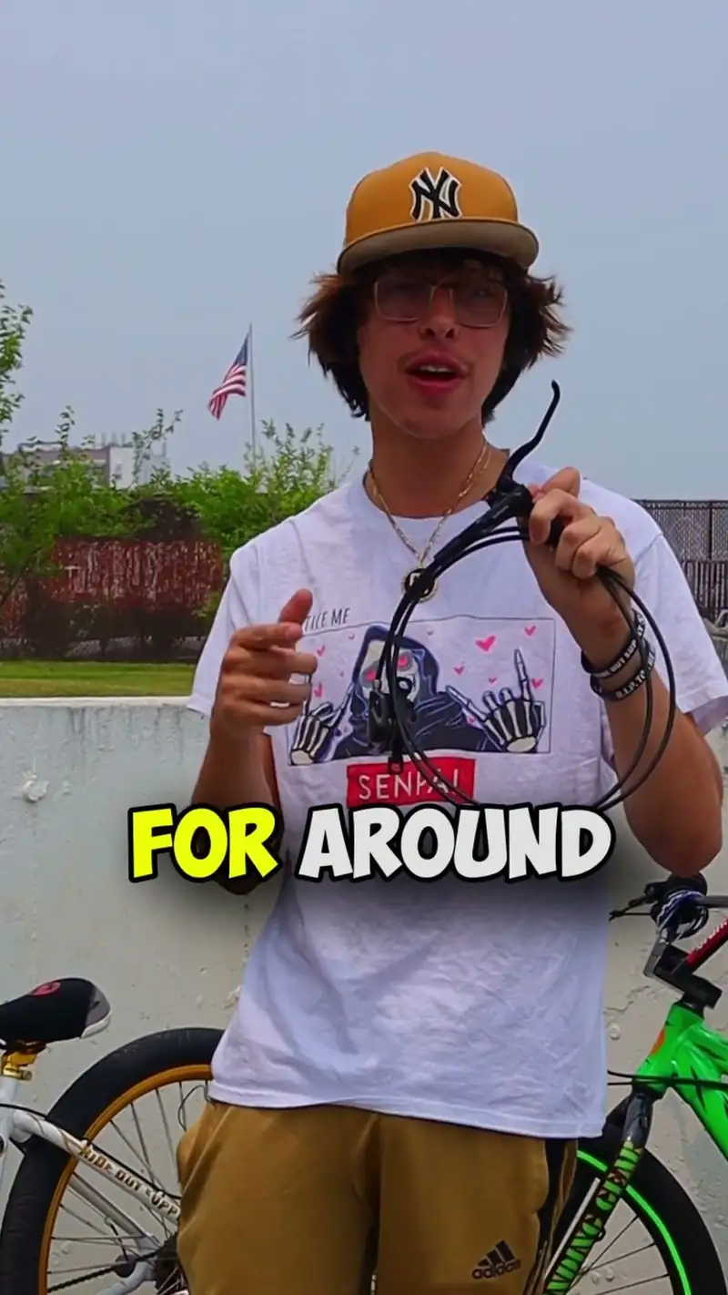 Christopher Maddaloni Jr. in a tan cap and glasses holding up a set of bike brake cables, with the caption FOR AROUND