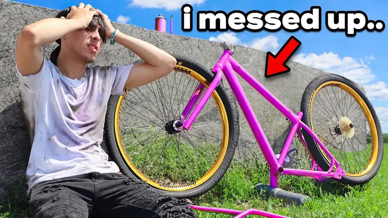 Christopher Maddaloni Jr. with his hands on his head beside a bike with a pink frame and gold wheels, under the words i messed up